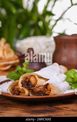 Hausgemachte, dünne Pfannkuchen. Die Äpfel werden in einer Butterkaramellsauce mit Rosinen und Zimt gekocht und zu einem dünnen Pfannkuchen gefüllt. Stockfoto