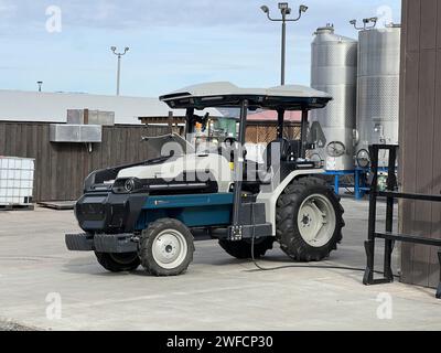 Elektrotraktor in der Nähe von Gärtanks aus Edelstahl auf einem Weingut, Sonoma, Kalifornien, 10. November 2023. Stockfoto