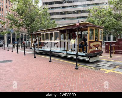 Legendäre Seilbahn mit Passagieren auf der California Street im Financial District, San Francisco, Kalifornien, 18. August 2023. Stockfoto