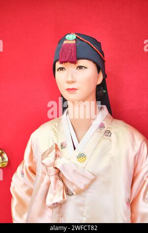 Eine Ausstellung alter, traditioneller, zeremonieller Kleidung, getragen von jemandem koreanischer Abstammung. Eine Frau in cremefarbenem Seidenmantel. Im Central State Museum Stockfoto