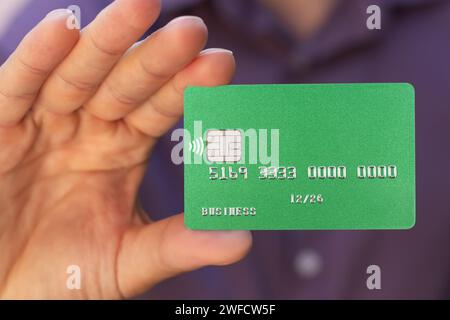 Nahaufnahme der grünen Kreditkarte, die in der Hand gehalten wird Stockfoto