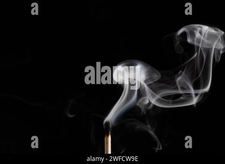 Rauch von einem Streichholz, das gerade rausgebracht wurde, isoliert auf schwarzem Hintergrund. Stockfoto