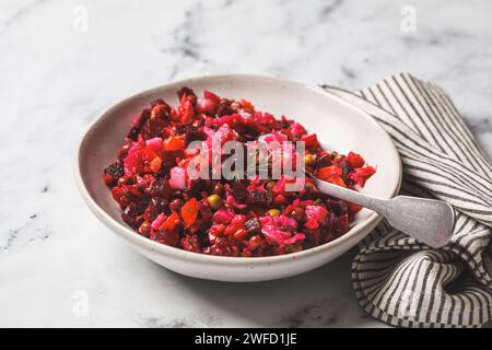 Russischer Rote-Bete-Vinaigrette-Salat mit grünen Erbsen, gekochtem Gemüse und Dill. Stockfoto