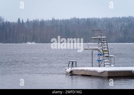 Winterbad in Finnland. Tauchplattform auf einem hölzernen Pier, mit Schnee bedeckt. Stockfoto