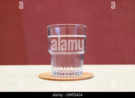 Nahaufnahme eines Glases Trinkwasser isoliert auf weißem Tisch Stockfoto