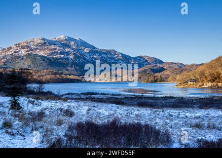 Loch Achray und ein schneebedeckter Ben Veranstaltungsort, Trossachs, Stirling, Schottland Stockfoto