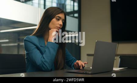 Nachdenklich zögernd zweifelhafte indische Frau Arbeit Laptop im Büro nachdenklich unsicher verwirrt arabische Mädchen wählen vergleichen Idee entscheiden weibliche Geschäftsführerin Stockfoto