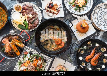 Auswahl an flachen Gourmet-Fisch- und Fleischgerichten. Blick von oben auf den Restauranttisch mit Menü mit leckeren Gerichten. Restaurant-Menü-Konzept. Stockfoto