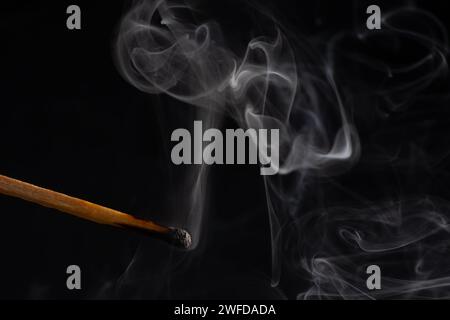 Rauch von einem Streichholz, das gerade rausgebracht wurde, isoliert auf schwarzem Hintergrund. Stockfoto