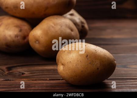 Frisch geerntete Kartoffeln auf einer rauen Holzoberfläche. Stockfoto