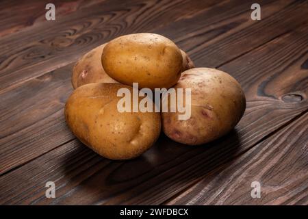 Frisch geerntete Kartoffeln auf einer rauen Holzoberfläche. Stockfoto