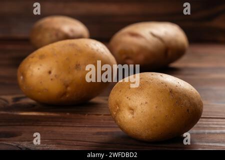 Frisch geerntete Kartoffeln auf einer rauen Holzoberfläche. Stockfoto