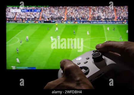 Dnipro, Ukraine, 28. september 2023: Mann spielt EA FC 24 mit Xbox-Controller auf dem Fernsehbildschirm, Stockfoto