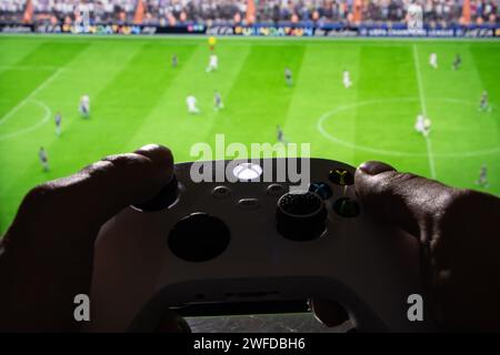 Dnipro, Ukraine, 28. september 2023: Mann spielt EA FC 24 mit Xbox-Controller auf dem Fernsehbildschirm, Stockfoto