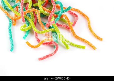 Bunte Gelee-Bonbons in Form der Stäbchen, mit Zucker bestreut auf weißem Hintergrund. Stockfoto