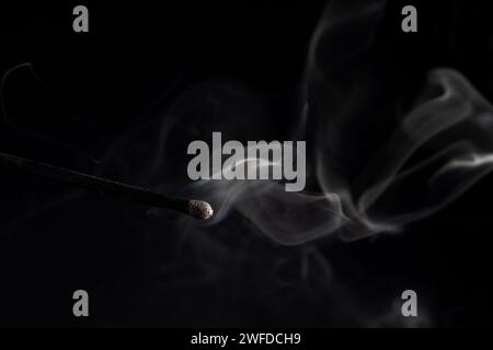 Rauch von einem Streichholz, das gerade rausgebracht wurde, isoliert auf schwarzem Hintergrund. Stockfoto
