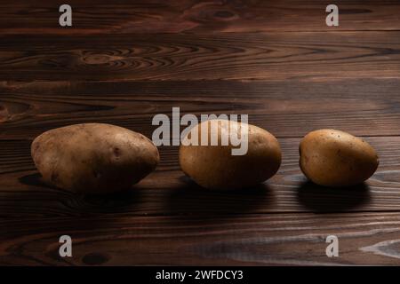 Frisch geerntete Kartoffeln auf einer rauen Holzoberfläche. Stockfoto