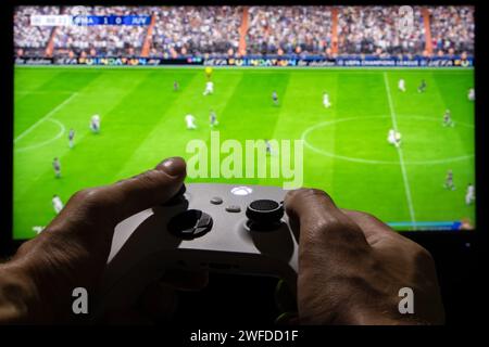 Dnipro, Ukraine, 28. september 2023: Mann spielt EA FC 24 mit Xbox-Controller auf dem TV-Bildschirm. Stockfoto