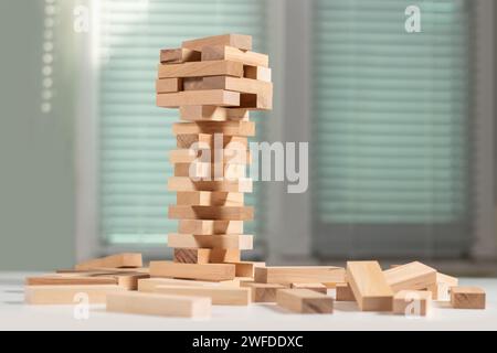 Brettspiel Turm aus Holzblöcken. Ein Turm aus ungleichmäßig verschobenen Holzbalken. Eine Lektion für Agilität, Logik und Koordination. Home Entertainment. Ba Stockfoto