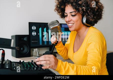 Führen Sie ein Podcast-Interview mit einem Gast im Home Office durch. Lateinische Frau synchronisiert VoiceOver für die Live-Radiosendung Stockfoto