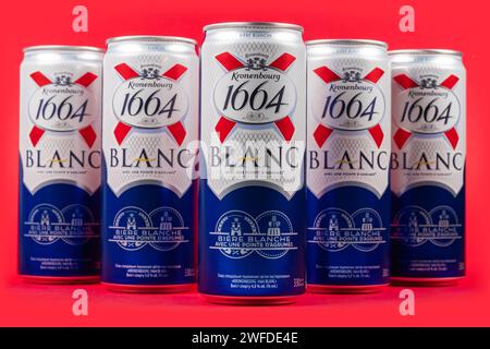 Dnipro, Ukraine, 13. oktober 2023: Aluminiumdosen der Biermarken Kronenbourg 1664 Blanc im Besitz der Carlsberg-Gruppe auf rotem Hintergrund. Stockfoto