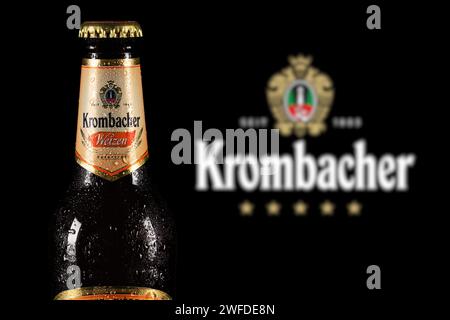 Dnipro, Ukraine, 18. oktober 2023: Krombacher Weizen Bier mit Tropfen auf Logo-Hintergrund. Die Krombacher Brauerei wurde 1803 in Deutschland gegründet. Stockfoto