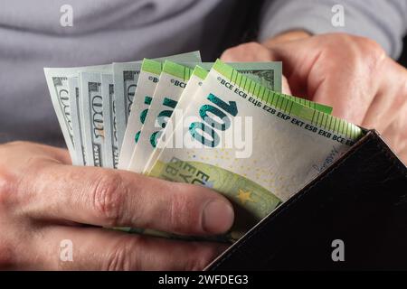 Bargeld in Höhe von 100 Dollar und 100 Euro-Scheine, Hintergrund in Dollar. Viele hundert Dollar-Scheine aus der Nähe. Dollar im Guthaben. Stockfoto