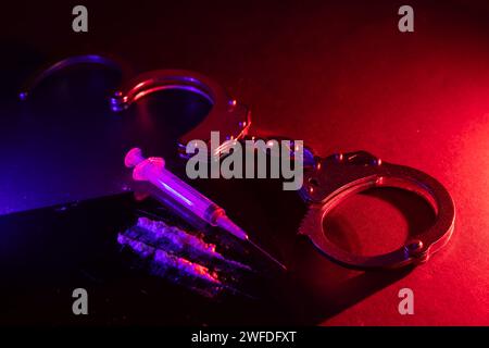 Drogenschmuggel und -Handel und Handschellen und Kokainsäcke auf schwarzem Hintergrund. Geschäfte mit illegalen Substanzen und Verhaftung Stockfoto