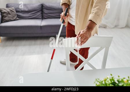 Zugeschnittene Ansicht eines blinden indianers in lässigem Outfit mit seinem Gehstock in der Küche Stockfoto