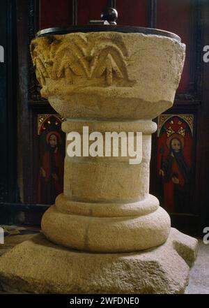 Restaurierte normannische (um 1100) Fontäne aus Pentewan-Stein in der St Winwaloe's Church, Gunwalloe, Cornwall, England, Großbritannien: Die breiten Pfeile repräsentieren die Dreifaltigkeit. Stockfoto