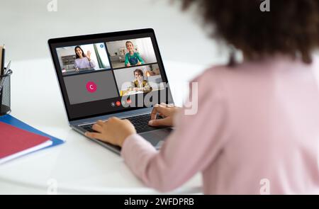 Rückansicht der Schülerin, die Online-Unterricht mit Laptop hat Stockfoto