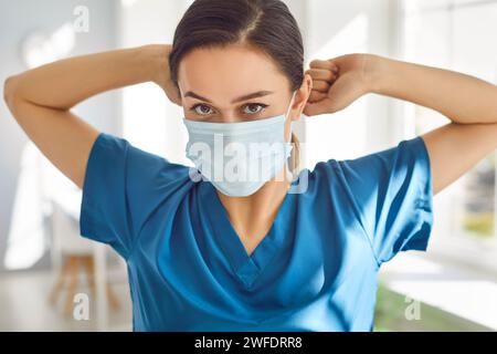 Porträt einer jungen Ärztin mit medizinischer Maske, die in der Klinik in die Kamera blickt. Stockfoto