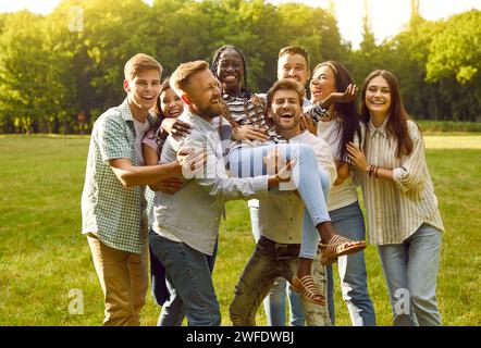 Multirassische Gruppe von fröhlichen besten Freunden, die gemeinsam Spaß haben und den Sommertag im Park genießen. Stockfoto