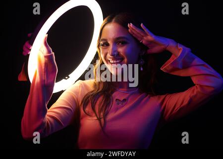 Porträt eines lächelnden Mädchens, das mit Ringlicht posiert Stockfoto