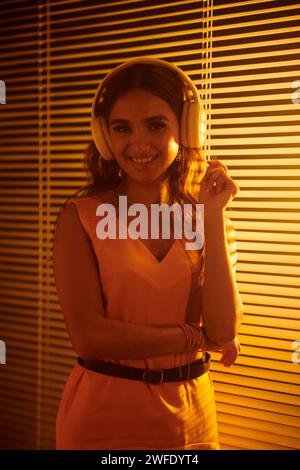 Porträt eines lächelnden indischen Mädchens in Kopfhörern, das gute Musik genießt Stockfoto