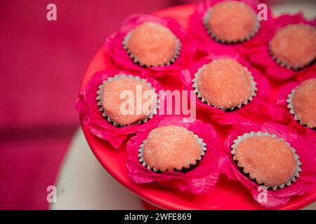 Verschiedene Cupcakes mit weißer Zuckerguss auf einem rosafarbenen Kuchenteller Stockfoto