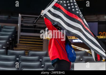 Frau läuft mit der Flagge der dünnen roten Linie bei der 8. Jährlichen BFit Challenge, die von der Boston Bruins Foundation organisiert wird. Stockfoto