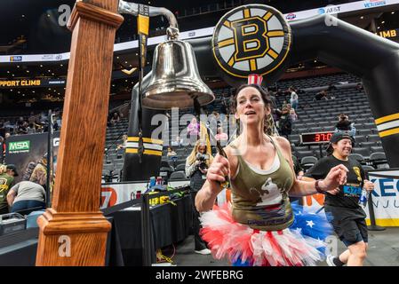 Frau in Tutu läutet an der Ziellinie der 8. Jährlichen BFit Challenge, organisiert von der Boston Bruins Foundation. Stockfoto