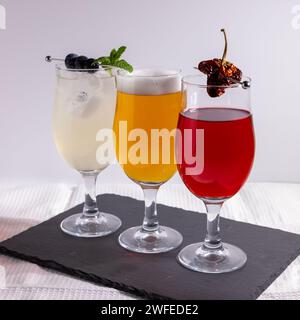 Cocktails und Bier werden im Studio vor weißem Hintergrund zubereitet und garniert Stockfoto