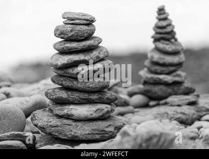 Nahaufnahme von zwei Türmen aus Kieselsteinen, die auf einem Kieselstrand gestapelt sind Stockfoto