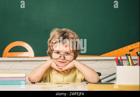 Schüler lernen Buchstaben und Zahlen. Kinder machen sich bereit für die Schule. Zu Hause Schulbildung. Freundliches Kind im Klassenzimmer in der Nähe der Tafel. Talentiertes Kind. Kind Stockfoto
