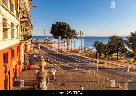 Nizza, Frankreich - 29. Juli 2022: Blick auf die Promenade Quai Rauba Capeu bei Sonnenuntergang neben dem Burgberg Colline du Chateau und dem historischen Swiss Hotel in Nizza auf Frenc Stockfoto