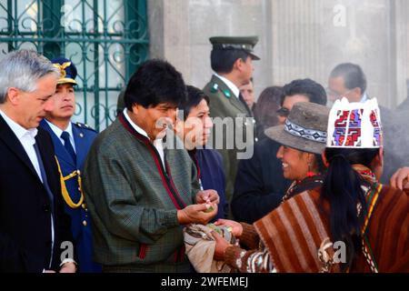 La Paz, BOLIVIEN; 24. Januar 2015. Eine Schamanin bietet dem bolivianischen Präsidenten Evo Morales bei einer Veranstaltung zum Beginn des Alasitas-Festivals in La Paz Kokablätter an. Das Anbieten von Kokablättern ist eine traditionelle Form der Begrüßung und des Respekts in vielen Andenkulturen. Der bolivianische Vizepräsident Alvaro Garcia Linera ist ganz links vom Bild, hinter ihm das Bildzentrum der Canciller/Außenminister David Choquehuanca Stockfoto