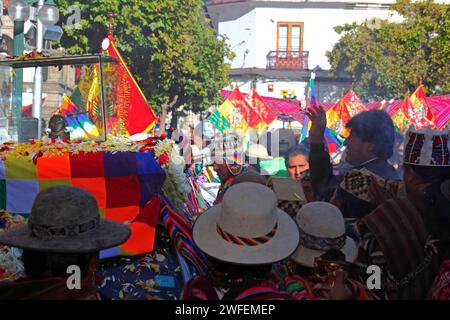 La Paz, BOLIVIEN; 24. Januar 2015. Der bolivianische Präsident Evo Morales (rechts, mit Silhouetten) wirft Blätter über eine antike illa (oder Statue) eines Ekeko (ein Gott des Überflusses der Aymara), während er durch die Straßen von La Paz gleitet, um seinen ersten Auftritt beim heute beginnenden Alasitas-Festival zu feiern. Die Statue ist etwa 2000 Jahre alt und wurde von der Pucara-Kultur hergestellt. Sie wurde 1858 von der archäologischen Stätte Tiwanaku in die Schweiz gebracht und im November 2014 vom Geschichtsmuseum Bern nach Bolivien zurückgegeben. Stockfoto