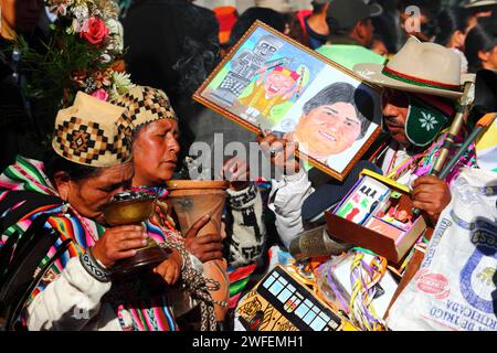 La Paz, BOLIVIEN; 24. Januar 2015. Schamaninnen und ein Mann in Ekeko (rechts), der ein Bild des bolivianischen Präsidenten Evo Morales hält, nehmen an einer Veranstaltung zum Beginn des Alasitas-Festivals in La Paz Teil. Ekekos sind Figuren/Götter des Überflusses, die in der Aymara-Folklore Glück und Fülle bringen, heute werden sie besonders mit dem Alasitas-Festival in Verbindung gebracht. Die Zeichnung wurde Evo Morales geschenkt, nachdem diese Bilder aufgenommen wurden. Stockfoto