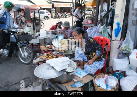 Frau, die Essen und andere billige Sachen auf der Straße in Downtown Phnom Penh, Kambodscha verkauft Stockfoto