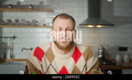 Porträt eines gutaussehenden Erwachsenen, der in die Kamera schaut und in der modernen Küche zu Hause lächelt Stockfoto