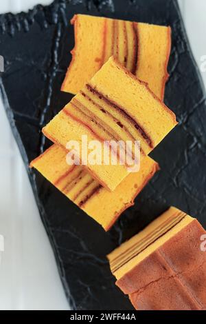 Schneiden Sie Philipines Layer Cake oder Lapis Filipina, Blick von oben auf Steinplatten für Imlek Chinese New Year Stockfoto