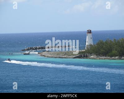 Ruhige Meereslandschaft mit weißem Leuchtturm, der an einem sonnigen Tag die zerklüftete Küste bewacht Stockfoto