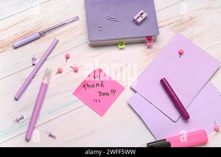 Haftnotiz mit Text DANKESCHÖN und Briefpapier auf Grunge Hintergrund Stockfoto